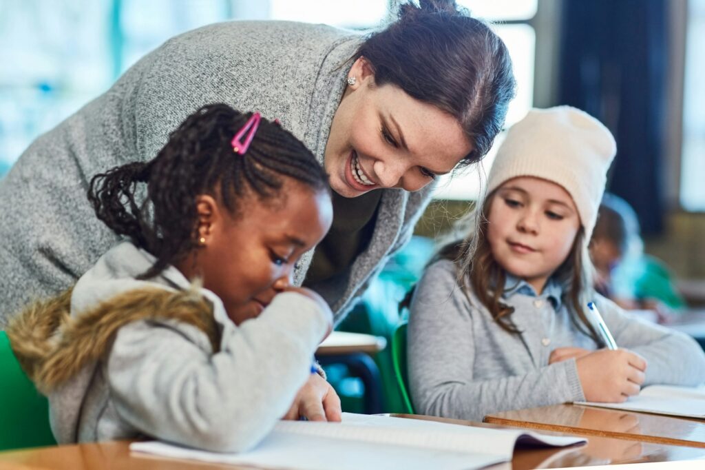 Cropped shot of elementary school girls getting help from their teacher in the classroom