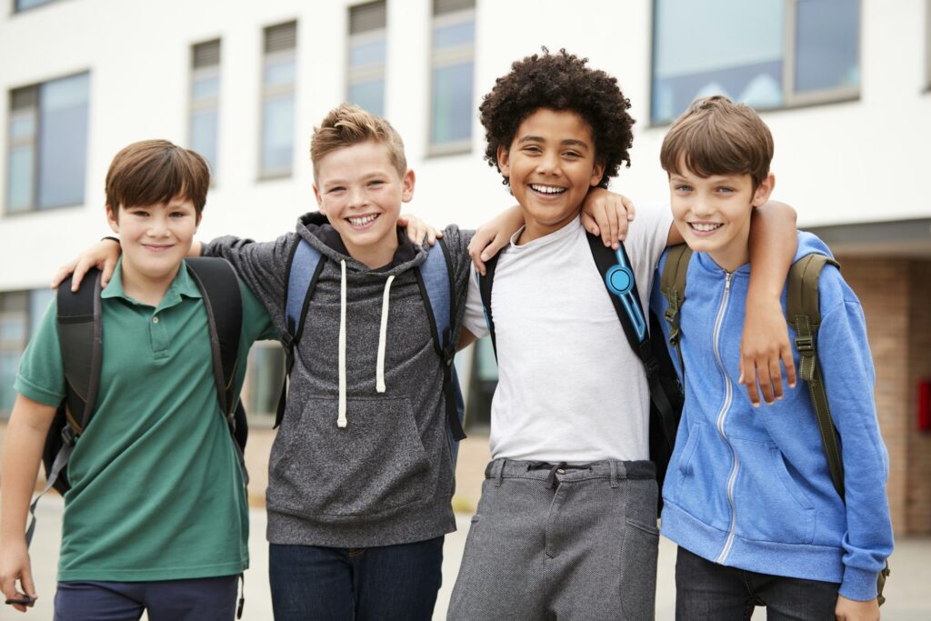 Portrait Of Male High School Student Friends Standing Outside School Buildings